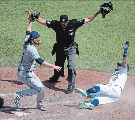 ?? TOM SZCZERBOWS­KI GETTY IMAGES ?? Kevin Pillar, right, of the Blue Jays slides home safely to score a run in the sixth inning as Ryne Stanek of the Tampa Bay Rays cannot tag him out in time during American League baseball action at Rogers Centre in Toronto on Sunday afternoon.