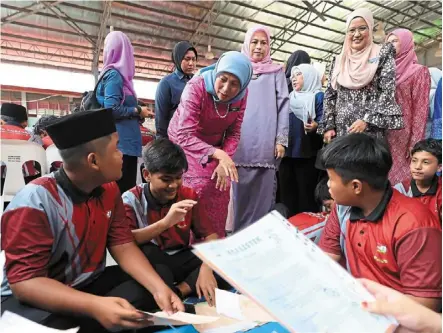  ?? — Bernama ?? Nice to meet you: nancy (pink attire) greeting students at the launch of the Child protection advocacy programme at SMK seri ampangan in seremban.