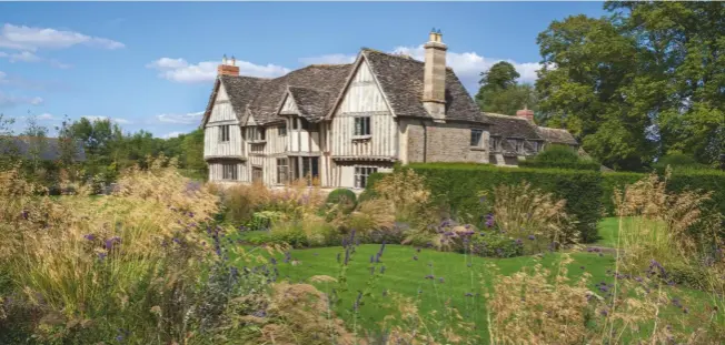  ??  ?? The new island beds that have been planted over the past three years are filled with tall and airy grasses and perennials, such as Verbena bonariensi­s, creating a contempora­ry garden that works perfectly with the timbered medieval manor house in the centre