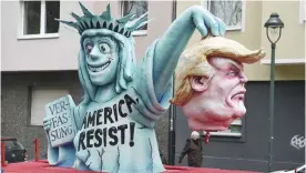  ?? —AFP ?? DUESSELDOR­F: A float showing US President Donald Trump and the Statue of Liberty are seen the Rose Monday carnival parade.