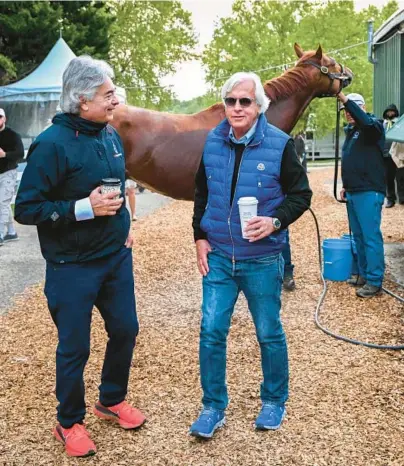  ?? JERRY JACKSON/BALTIMORE SUN ?? Trainers Bob Baffert, right, and Gustavo Delgado talk outside the Stakes Barn at Pimlico Race Course on Friday morning as Kentucky Derby winner Mage is bathed.