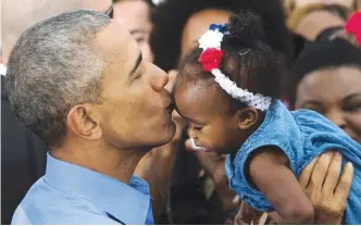  ?? — AFP ?? FLORIDA: US President Barack Obama holds up a baby after speaking in Kissimmee, Florida as he campaigns for Democratic presidenti­al nominee Hillary Clinton during a Hillary for America campaign event.