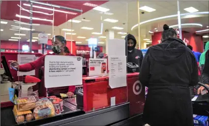  ?? AP Photo/Bebeto Matthews ?? An associate (left) ring customer purchases at a Target store, on Oct. 20 in New York.