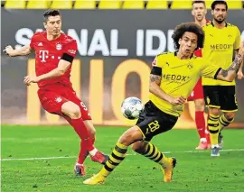 ??  ?? Bayern Munich’s Robert Lewandowsk­i has his shot blocked down by Borussia Dortmund’s Axel Witsel at Signal Iduna Park yesterday