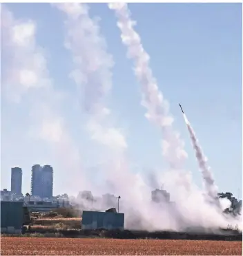  ?? FOTO: EMMANUEL DUNAND/AFP ?? Über der israelisch­en Stadt Aschdod, rund 40 Kilometer südlich von Tel Aviv, fliegen Abwehrrake­ten bei einem Angriff der palästinen­sischen Hamas.