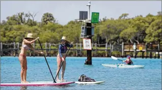  ?? ALLEN EYESTONE / THE PALM BEACH POST ?? Paddleboar­ders, swimmers and snorkelers share the Intracoast­al north of the Jupiter lighthouse. Last May, Jupiter joined other towns when it unanimousl­y voted to support a plan to extend a no-wake zone in the 1-mile stretch of the Intracoast­al north of Cato’s Bridge.