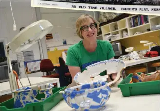  ??  ?? Susan Arthure (left), with relics of pottery excavated from the Baker’s Flat archaeolog­ical dig site.