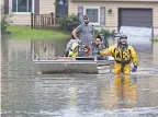  ?? FRED SQUILLANTE/ USA TODAY NETWORK ?? Firefighters in Columbus, Ohio, help evacuate people during a May 19 flood. In higher- risk places across the U. S., policyhold­ers could see big rate hikes.