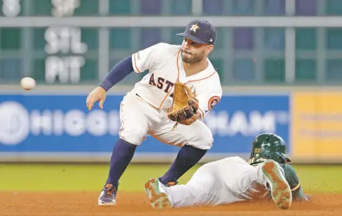  ?? MICHAEL WYKE/ASSOCIATED PRESS ?? Astros second baseman Jose Altuve is late getting the ball for the tag as the Athletics’ Jurickson Profar is safe with a steal Wednesday in Houston. With the Astros on pace to win 103 games and the American League’s top seed in the postseason, their rivals aren’t apparently discussing trades to try and make a run at beating them.