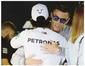  ??  ?? A friend in need: Mercedes driver Lewis Hamilton (left) hugging Cristiano Ronaldo at the pit lane ahead of the second practice session at the Monaco racetrack on Thursday. — AP