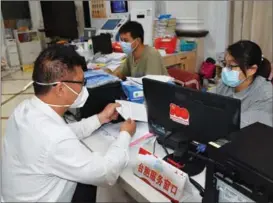  ?? PROVIDED TO CHINA DAILY ?? Wang Ting-wei (left) helps compatriot­s from Taiwan apply for medical insurance in Fuzhou, Fujian province, in December.