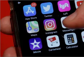  ?? AP Photo/Jeff ChIu ?? This July 10 photo shows an Associated Press reporter holding a phone showing the Instagram app icon in San Francisco.