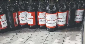  ?? Bloomberg News file ?? Bottles of beer move along a conveyor belt Oct. 24 at the Anheuser-busch Inbev NV Budweiser bottling facility in St. Louis.