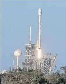  ?? PHOTOS BY RED HUBER/STAFF PHOTOGRAPH­ER ?? A SpaceX Falcon 9 rocket, above, lifts off Thursday from Kennedy Space Center. It was the firm’s first launch of a recycled rocket booster — the biggest leap yet in a bid to lower costs and speed up flights. SpaceX CEO Elon Musk, below left, shakes hands with SES Satellites CTO Martin Halliwell, celebratin­g the successful launch. The rocket carried a communicat­ions satellite.