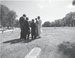  ?? Associated Press ?? ■ In this July 17, 2015, file photo, a family gathers in prayer as they visit a family member buried in the Islamic Garden at Restland Cemetery in Dallas. Leaders of a rural Texas town have approved design plans for a Muslim cemetery three years after the project was first met with derision and claims that it was a precursor to a Muslim training center. The city council in Farmersvil­le on Thursday OK’d the cemetery plans submitted by the Islamic Associatio­n of Collin County.