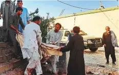  ?? AFP ?? Men carry the body of a victim to an ambulance after the suicide bombing at a Shiite mosque in Kunduz yesterday.