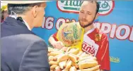  ??  ?? PAL JOEY: Fallible human judges initially logged Joey Chestnut’s 74 hot dogs scarfed Wednesday as a mere 64.