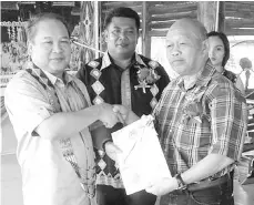  ??  ?? Rubin (left) presenting the Mamagun Advisory Council appointmen­t letter to Kadoh. Also seen is Mamagun president Rudy Sulaiman Mairi (centre).