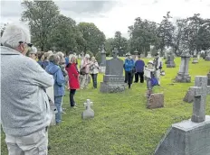  ?? BOB TYMCZYSZYN/POSTMEDIA NEWS ?? Isabel Bachman with the Welland Canal Fallen Workers Memorial Task Force leads a group through the old part of Victoria Lawn Cemetery Saturday in St. Catharines. The tour brought to life the stories of the men who died building the fourth Welland Canal.