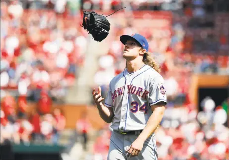  ?? Jeff Roberson / AP ?? Mets pitcher Noah Syndergaar­d flips his glove as he walks off the field after being removed during the eighth inning of a game at St. Louis on April 26. Syndergaar­d is on the disabled list with hand, foot and mouth disease.