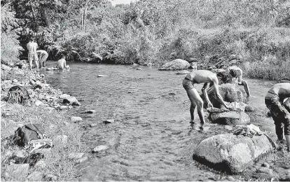  ?? MOISÉS CASTILLO/AP ?? Centroamer­icanos lavan su ropa y se asean en un río de Chiapas.