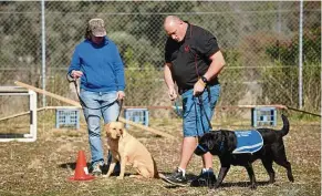  ??  ?? Former Australian military police officer Ashley Smith (right), who served in East Timor and with the Australian Border Force, training with Leroy, his black Labrador service dog.