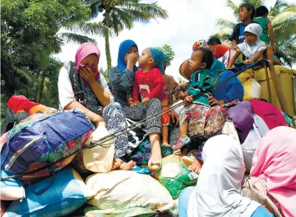  ?? AP FOTO ?? DISPLACED. Residents, mostly women and children, flee Marawi City with their belongings on board trucks as government troops battle Muslim militants for control of the city. The battle enters its second week.