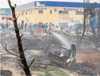  ?? ALBERTO DÍAZ ?? Los bomberos se emplean en enfriar los restos de las chabolas