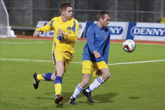  ?? Photos by Domnick Walsh ?? Cormac Mulvihill, Sporting Listowel (in yellow) and David Kelliher, Classic B, in action during their Denny Division 1B clash at Mounthawk Park