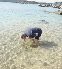  ?? FOTOS (3):HÖHLING ?? Gastronom Paolo füttert die Fische im Meer vor seiner Strandbar „Li Caracoli“mit Brot – mit dem Mund.