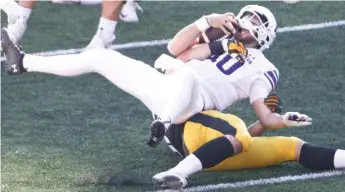  ?? GETTY IMAGES ?? Brendan Sullivan is sacked in the first half by Iowa’s Logan Lee. NU had 177 yards of total offense.