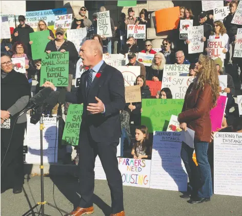  ??  ?? Liberal MLA Mike de Jong addresses protesting farmers outside the legislatur­e in Victoria on Monday. He says farmers in B.C. “have had enough and ... are standing up and are going to demand a little respect.” Farmers are concerned two bills will hinder their ability to raise families on their land.