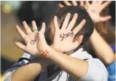  ?? Joe Raedle / Getty Images ?? A student with the words “Don't shoot” written on her hands walks out with Marjory Stoneman Douglas High classmates in Parkland, Fla.