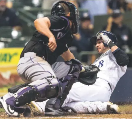  ?? Tom Lynn,The Associated Press ?? The Milwaukee Brewers’ Ryan Braun slides past the tag of Rockies catcher Nick Hundley, scoring on Hernan Perez’s two-RBI triple during the seventh inning Tuesday night at Miller Park in Milwaukee.