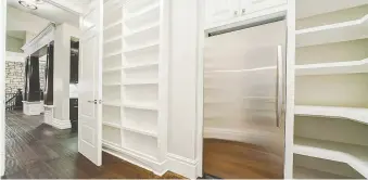  ?? HOMES BY US ?? This walk-through pantry featuring solid shelving offers a spacious storage solution.