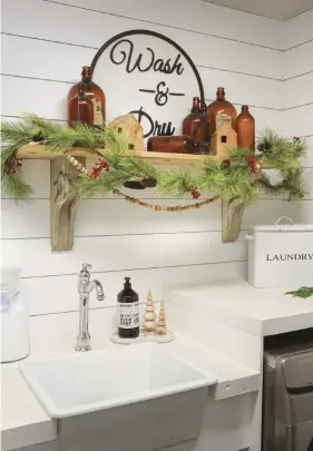  ?? ?? (right) Tamela’s signature simplicity carries into the laundry room with bright white counters and shiplap walls. A collection of vintage bottles is dressed up for Christmas with a garland.