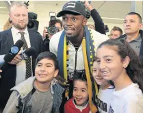  ??  ?? Usain Bolt poses with fans at Sydney airport.