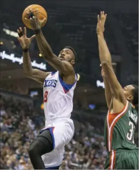  ?? TOM LYNN — THE ASSOCIATED PRESS ?? Philadelph­ia 76ers’ Tony Wroten, left, lays the ball up as Milwaukee Bucks’ John Henson defends during Friday’s game in Milwaukee.