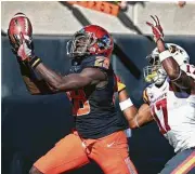  ?? Sue Ogrocki / Associated Press ?? Oklahoma State wide receiver James Washington, left, catches a pass in front of Iowa State defensive back Jomal Wiltz on Saturday at Stillwater, Okla.