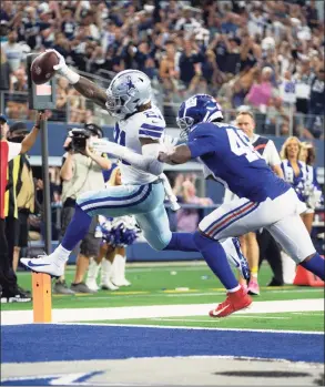  ?? Brandon Wade / Associated Press ?? Cowboys running back Ezekiel Elliott scores a touchdown as Giants linebacker Tae Crowder defends on Sunday in Arlington, Texas. Dallas won 44-20.