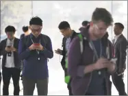  ?? Bloomberg ?? Attendees view mobile devices ahead of an Apple Inc. event in Cupertino, Calif., on Wednesday.