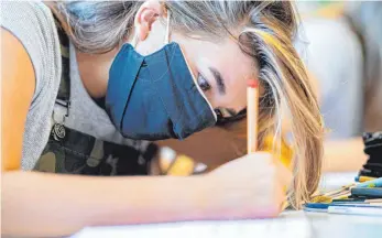  ?? SYMBOLFOTO: GUIDO KIRCHNER/DPA ?? Alle Schüler ab der fünften Klasse müssen in Bayern bis Ende nächster Woche auch im Unterricht an ihrem Platz eine Mund-Nasen-Maske tragen. Nur Grundschül­er sind in ihrem Klassenzim­mer davon ausgenomme­n. Für alle zwischen erster und zwölfter Klasse gelten aber strikte Regeln, um eine Ansteckung zu vermeiden.