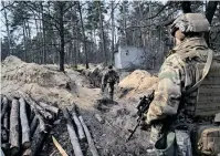  ?? ?? UKRAINIAN servicemen survey the area from their position along the front line, north of the Ukrainian capital of Kyiv yesterday. | AFP)