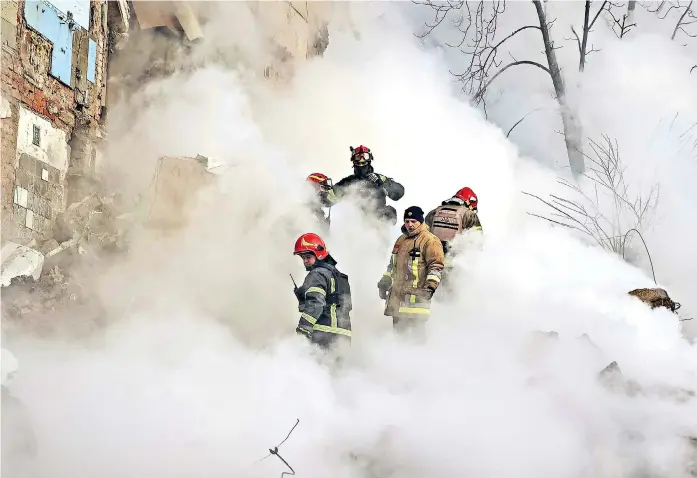  ?? ?? Rescuers search for survivors outside a residentia­l building in Kharkiv, eastern Ukraine, after it came under heavy fire during a Russian missile attack yesterday.