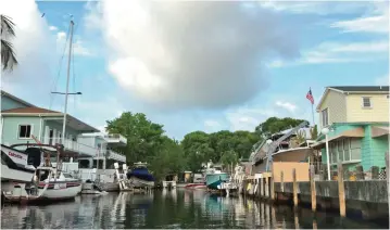  ??  ?? Photos shows houses and boats on a canal in a neighborho­od at Key Largo, Florida.