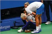  ?? SETH WENIG /AP ?? Novak Djokovic checks on the line judge he hit with a ball after losing a point to Pablo Carreno Busta. The resulting default ended Djokovic’s bid for an 18th Grand Slam title.