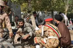  ??  ?? Soldiers and a cleric sit close to the ground seeking cover at the scene of an attack on a military parade in Ahvaz (AFP/Getty)