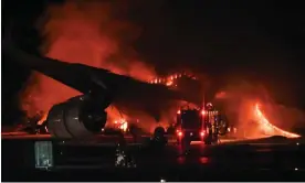  ?? Richard A Brooks/AFP/Getty Images ?? The Japan Airlines passenger plane on fire on the tarmac at Haneda airport. Photograph: