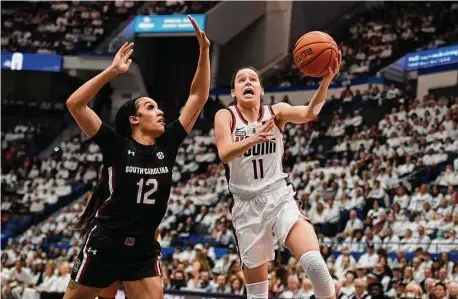  ?? Jessica Hill/Associated Press ?? UConn’s Lou Lopez-Senechal (11) shoots around South Carolina’s Brea Beal (12) on Sunday in Hartford.