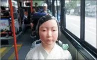 ?? YAO QILIN / XINHUA ?? “Comfort women” statues are seated on public buses in Seoul on Monday and for the coming month to remind people of the trauma suffered by women and girls who were forced into sexual slavery by the Japanese before and during World War II.